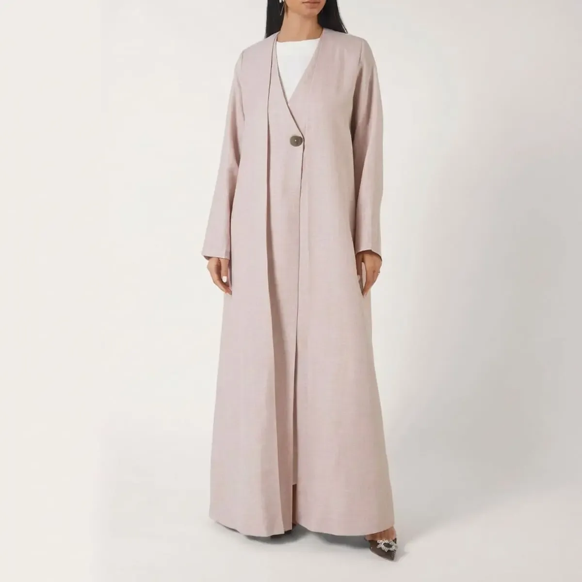 Luxury blush beige wrap abaya featuring a minimalist V-neckline, single-button closure, premium linen-look fabric, and a flowing full-length silhouette by LAYL.